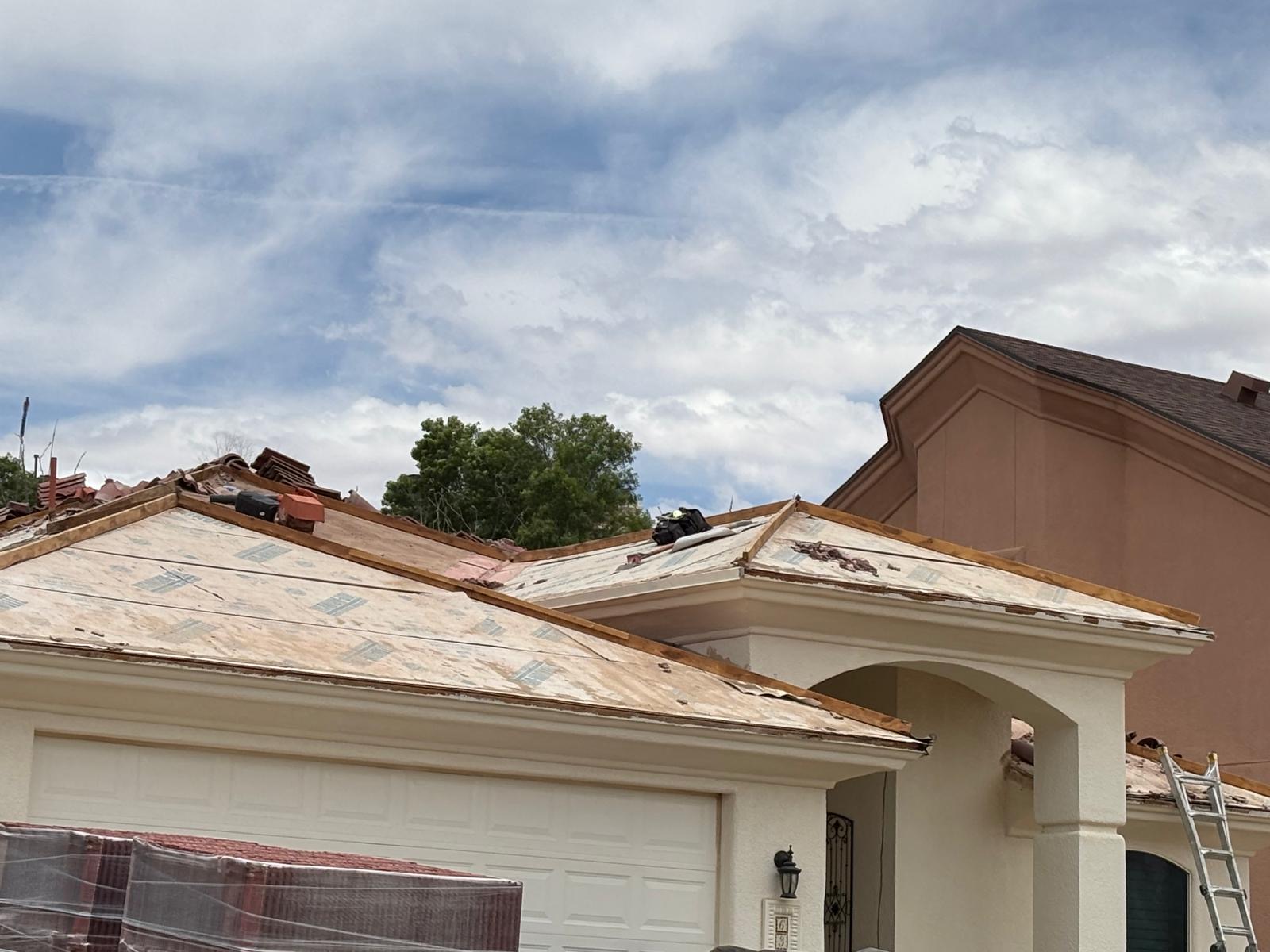 Tile roof tear-off in progress with fresh decking installed